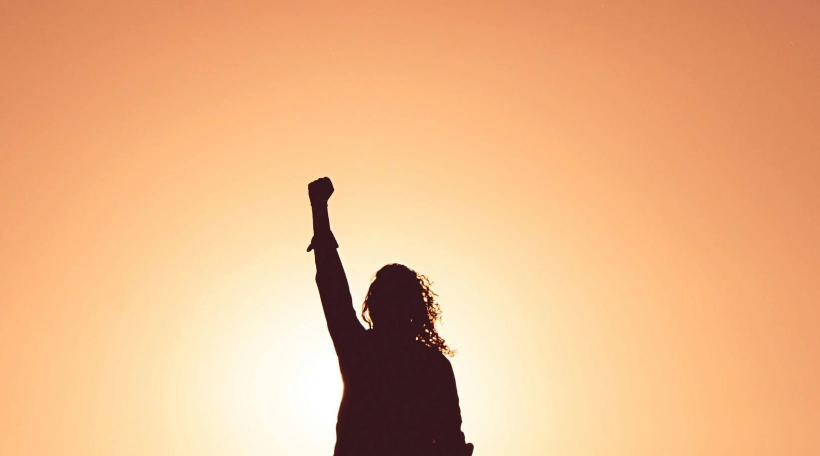 An individual expressing empowermen as the sun sets