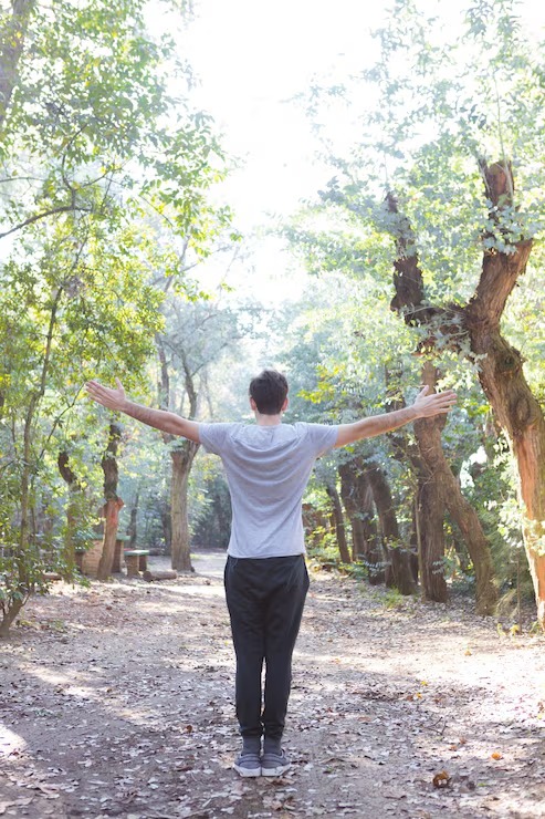 Tourist man with arms happy with nature near river travel concept